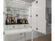 Elegant built-in bar cabinet with glass shelves, filled with liquor and glassware, perfect for entertaining guests at 301 Quay Commons # 1610, Sarasota, FL 34236