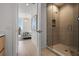 Hallway view of the bathroom featuring walk-in shower with glass doors and a view of the bedroom at 301 Quay Commons # 1610, Sarasota, FL 34236