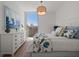 Bright bedroom with a large window, white dresser, and colorful bedding at 301 Quay Commons # 1610, Sarasota, FL 34236