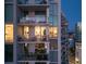 Modern building exterior featuring multiple balconies with glass railings and views of the city lights at dusk at 301 Quay Commons # 1610, Sarasota, FL 34236