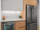 Modern kitchen with stainless steel fridge, wood cabinetry, and sleek countertops for a clean and contemporary look at 301 Quay Commons # 1610, Sarasota, FL 34236