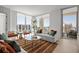Bright, open living room featuring comfortable seating, a glass-railed balcony, and views of city buildings and the sea at 301 Quay Commons # 1610, Sarasota, FL 34236