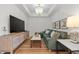 Comfortable living room featuring a plush green sectional sofa, large TV, and stylish decor at 301 Quay Commons # 1610, Sarasota, FL 34236