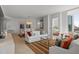Well-lit living room showcasing stylish furnishings, light wood floors, and open access to a bedroom at 301 Quay Commons # 1610, Sarasota, FL 34236