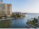Overhead view of a waterfront resort featuring a pool, palms, and a bay view with a bridge in the distance at 301 Quay Commons # 507, Sarasota, FL 34236