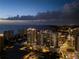 Aerial view of a waterfront community and roadway at dusk, with lights from buildings shining at 301 Quay Commons # 507, Sarasota, FL 34236