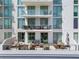 Wide balcony with dining and lounge areas, offering a relaxing outdoor space with city views at 301 Quay Commons # 507, Sarasota, FL 34236