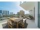 Large balcony perfect for entertaining with seating, including large outdoor dining table and views of the skyline at 301 Quay Commons # 507, Sarasota, FL 34236