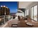 Relaxing outdoor balcony with patio furniture including outdoor umbrella and views of city buildings at 301 Quay Commons # 507, Sarasota, FL 34236