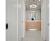 Modern bathroom featuring double sink vanity with wood cabinets and elegant chandelier lighting at 301 Quay Commons # 507, Sarasota, FL 34236