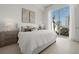 Bright bedroom features a large sliding door to the outdoor balcony and neutral tones at 301 Quay Commons # 507, Sarasota, FL 34236