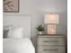 Cozy bedroom decor features a stylish lamp, a gray nightstand and complementary artwork at 301 Quay Commons # 507, Sarasota, FL 34236