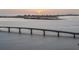 A bridge over the bay with the skyline silhouetted by a sun rising over the horizon at 301 Quay Commons # 507, Sarasota, FL 34236