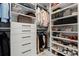 Organized walk-in closet with shelving, drawers, and hanging racks for ample storage at 301 Quay Commons # 507, Sarasota, FL 34236