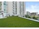 Spacious community dog park with synthetic grass and building views at 301 Quay Commons # 507, Sarasota, FL 34236