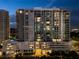 Stunning high-rise condo building featuring modern architecture and city views at twilight at 301 Quay Commons # 507, Sarasota, FL 34236