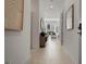 Bright hallway leads to living room with tile flooring, art, and a round mirror at 301 Quay Commons # 507, Sarasota, FL 34236