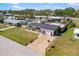 Well-maintained home featuring a dark roof, lush green lawn, and colorful flowerbeds along the driveway at 309 Glen Oak Rd, Venice, FL 34293