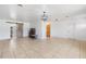 Open-concept living room with tile floors, barn door, modern light fixture, and ample space at 309 Glen Oak Rd, Venice, FL 34293