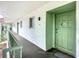 Condo entrance featuring a green front door, outdoor lighting, and exterior walkway at 3606 Beneva Rd # 506, Sarasota, FL 34232