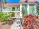 Charming condo exterior featuring a brick walkway, green doors and trim, and colorful landscaping at 3606 Beneva Rd # 506, Sarasota, FL 34232