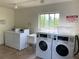 Community laundry room featuring coin operated washers, dryers, laundry sink and tile floors at 3606 Beneva Rd # 506, Sarasota, FL 34232