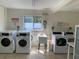 A community coin laundry room with multiple washers, dryers, a laundry sink and tile floors at 3606 Beneva Rd # 506, Sarasota, FL 34232