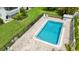 Overhead shot of rectangular in-ground pool surrounded by brick pavers, green grass and metal fencing at 3606 Beneva Rd # 506, Sarasota, FL 34232