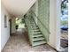 Exterior staircase featuring green railings and decorative green lattice walls on a brick floor at 3606 Beneva Rd # 506, Sarasota, FL 34232