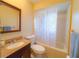 Well-lit bathroom featuring a vanity sink, toilet, and bathtub with shower combo at 389 Millport Nw St, Port Charlotte, FL 33948