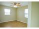 Light-filled bedroom with wood floors, a ceiling fan, and natural light from two windows at 389 Millport Nw St, Port Charlotte, FL 33948