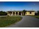 Charming home featuring a large, paved driveway and a well-manicured lawn at 389 Millport Nw St, Port Charlotte, FL 33948