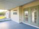 Covered patio area with double doors to the home's interior and view of the yard at 389 Millport Nw St, Port Charlotte, FL 33948