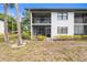 Exterior view of condo unit showing private, screened-in patio/balcony and mature landscaping at 4325 46Th W Ave # 104, Bradenton, FL 34210