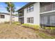 Exterior view of two-story condo building showing private, screened-in balconies and mature landscaping at 4325 46Th W Ave # 104, Bradenton, FL 34210