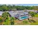 Aerial view of a home featuring a screened pool, patio area, and lush landscaping at 4487 Glebe Farm Rd, Sarasota, FL 34235