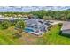 Aerial view showcasing a home with a pool, solar panels, screened lanai, and well-manicured lawn at 4487 Glebe Farm Rd, Sarasota, FL 34235