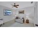 Cozy bedroom featuring a ceiling fan, a comfortable seating area, and ample natural light from a nearby window at 4487 Glebe Farm Rd, Sarasota, FL 34235