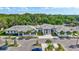 A stunning exterior of a modern building with ample parking, palm trees, and beautiful landscaping at 4487 Glebe Farm Rd, Sarasota, FL 34235