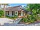 A well-maintained exterior with mature landscaping leads to the entrance of a charming single-story building at 4487 Glebe Farm Rd, Sarasota, FL 34235