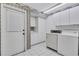 Functional laundry room with white appliances, ample cabinet space, and practical tile flooring at 4487 Glebe Farm Rd, Sarasota, FL 34235