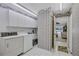 Bright laundry room featuring white cabinets, appliances, and a classic laundry sink at 4487 Glebe Farm Rd, Sarasota, FL 34235