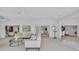 Bright living room with white walls, modern furniture, artwork, and access to other rooms through wide archways at 4487 Glebe Farm Rd, Sarasota, FL 34235