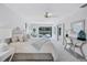 Bright main bedroom boasts white furniture, outdoor views, and a tranquil sitting area at 4487 Glebe Farm Rd, Sarasota, FL 34235