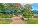 A relaxing park area with tables and benches under green umbrellas, offering a perfect spot for peaceful picnics at 4487 Glebe Farm Rd, Sarasota, FL 34235