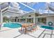 Outdoor dining beside a refreshing pool and spa, all within a screened enclosure at 4487 Glebe Farm Rd, Sarasota, FL 34235