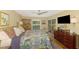 Spacious bedroom with wood floors, a ceiling fan, sliding glass doors, and ample natural light at 4489 Longmeadow # 74, Sarasota, FL 34235