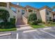 Charming condo exterior with brick stairway, neatly trimmed bushes, and two designated parking spots at 4489 Longmeadow # 74, Sarasota, FL 34235