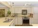 Bright kitchen with white cabinets, stainless steel appliances, and stylish lighting at 4489 Longmeadow # 74, Sarasota, FL 34235
