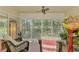 Relaxing screened porch with wicker chairs and a beautiful view of the lush backyard at 4489 Longmeadow # 74, Sarasota, FL 34235